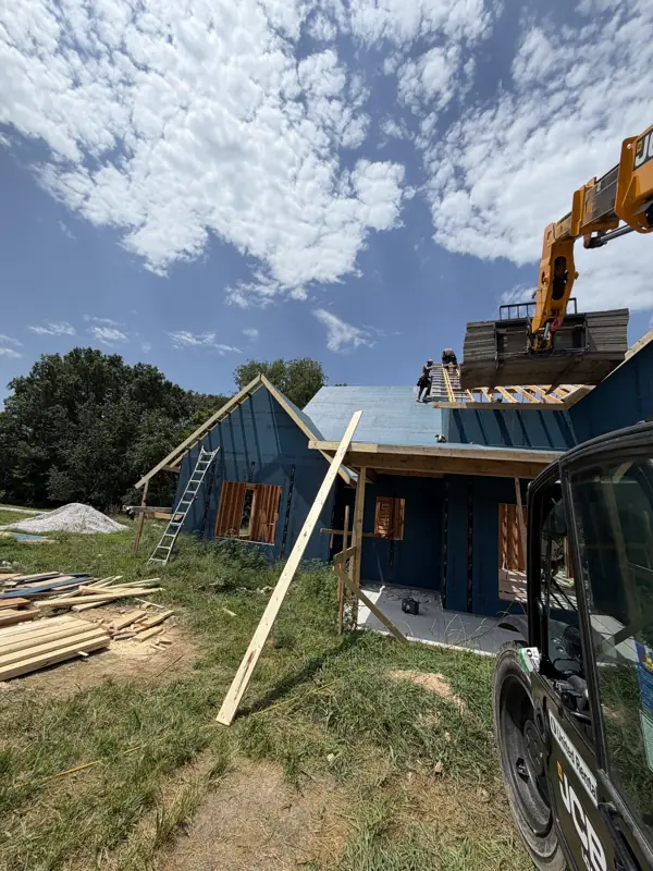 Crane setting trusses on the gabled home