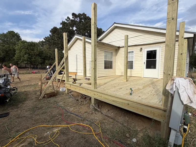 New covered deck addition being framed onto the back of an existing home