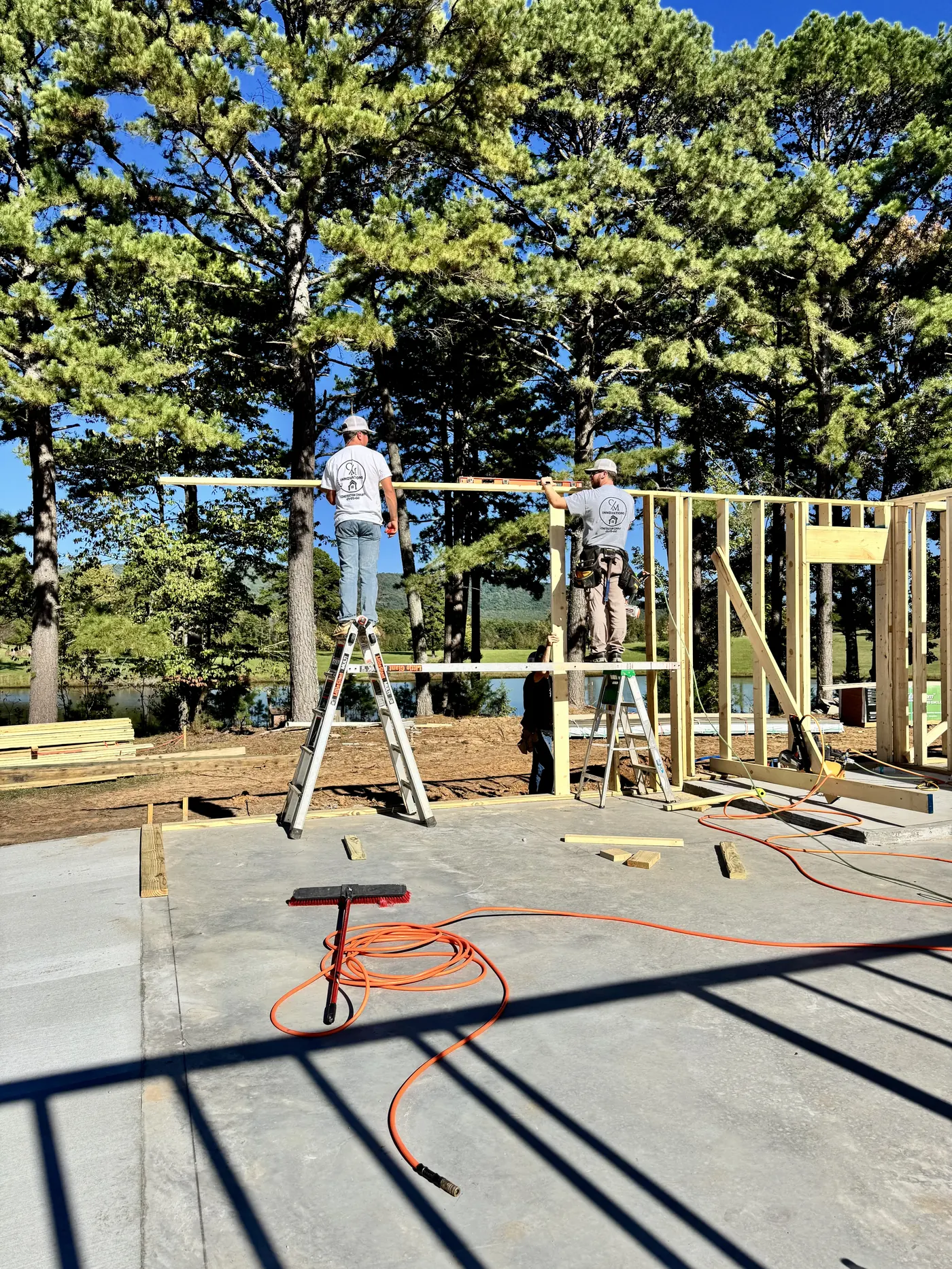 Two framers on ladders raising a wall