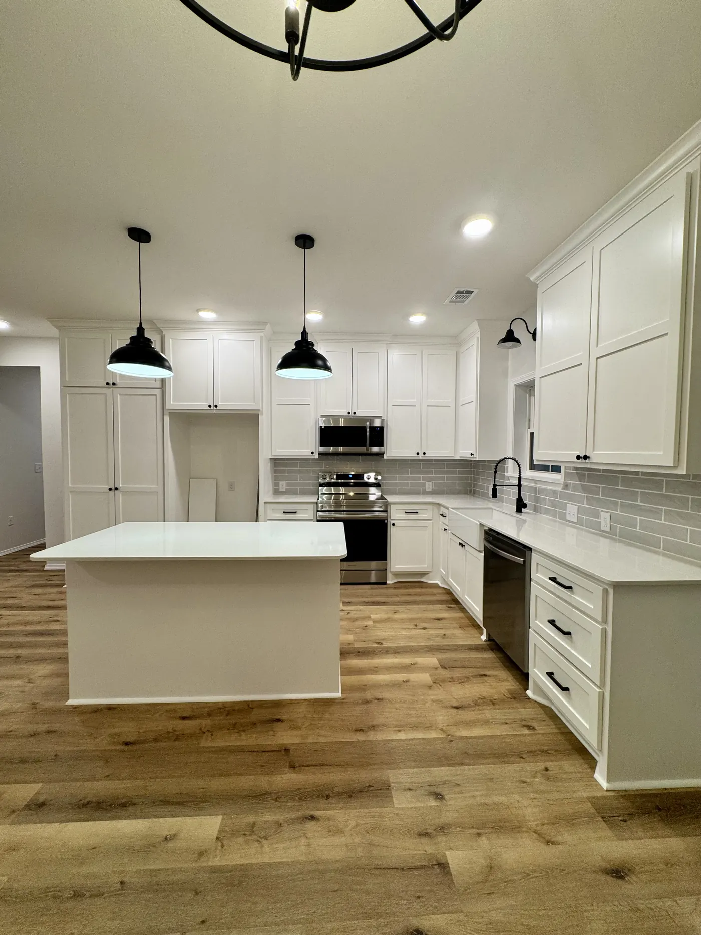 White shaker kitchen with island and black pendant lights