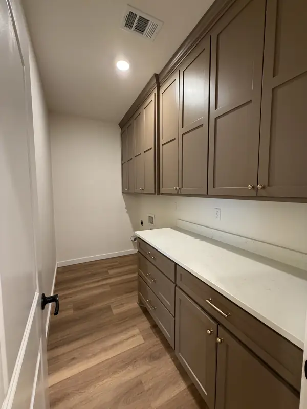 Laundry room with upper and lower cabinets and quartz counter