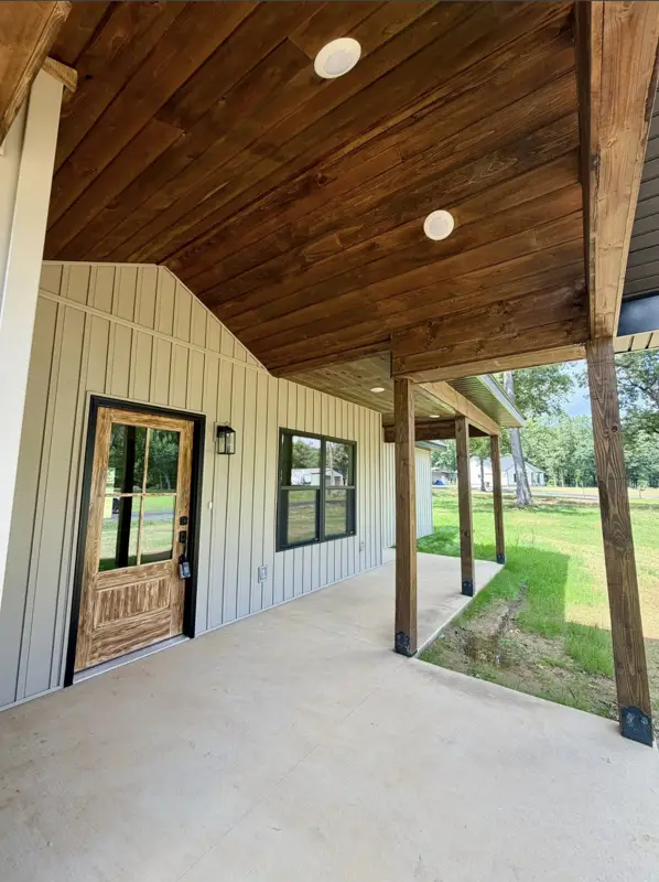 Covered porch with stained wood ceiling and timber posts