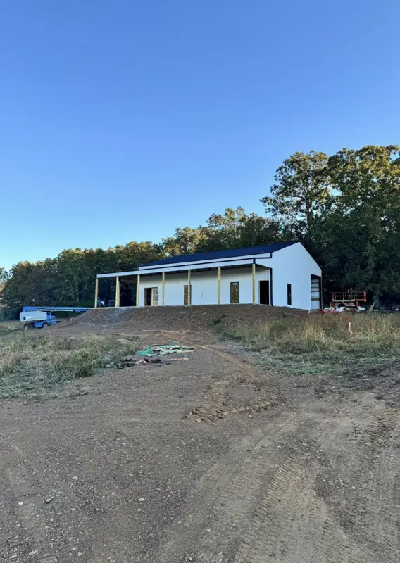 White metal shop with living quarters at dusk